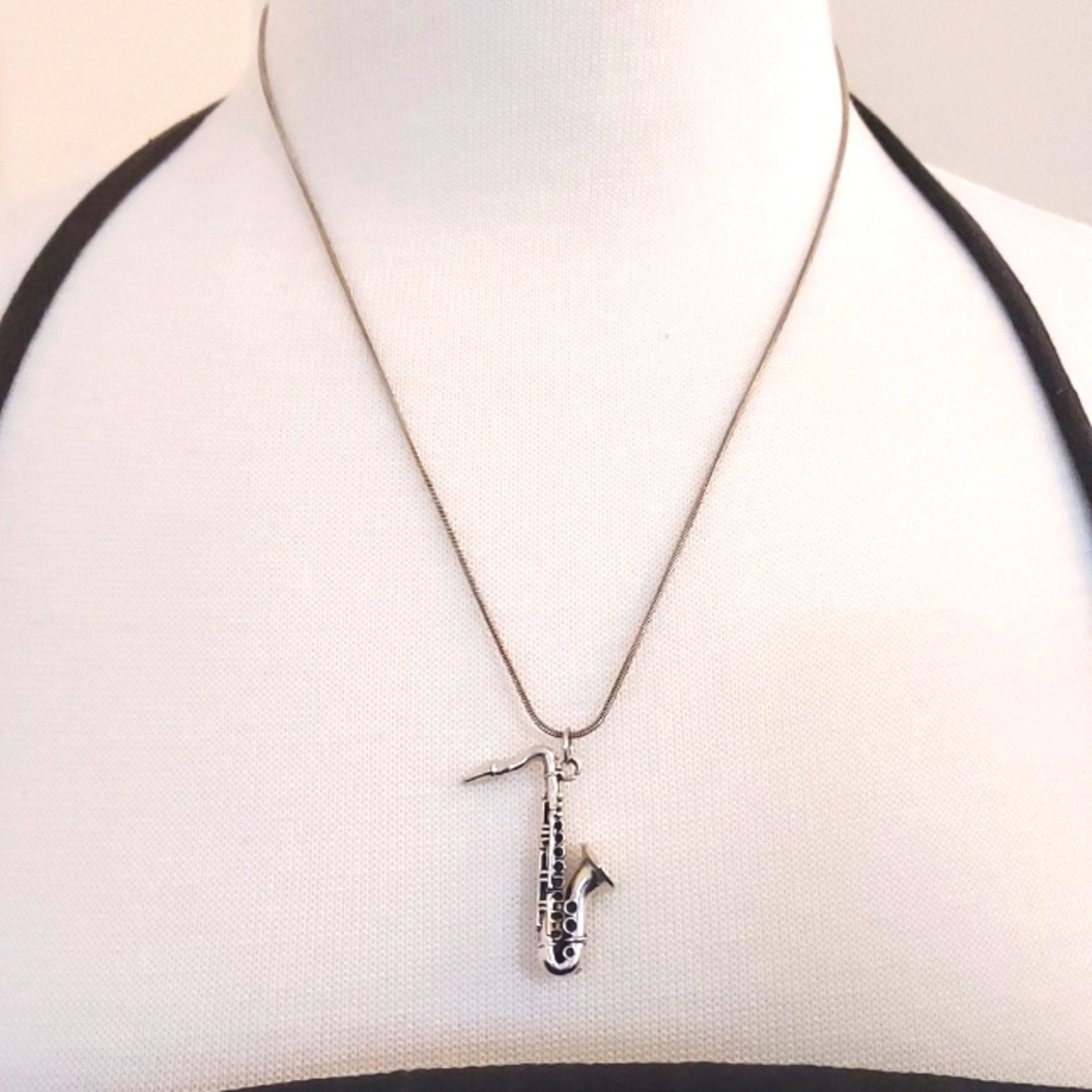 Silver trumpet pendant on a chain. The chain is marked, but the trumpet isn't.